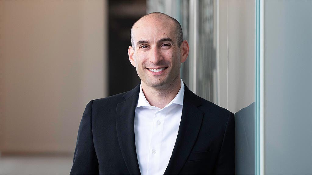 A man in a suit smiling.