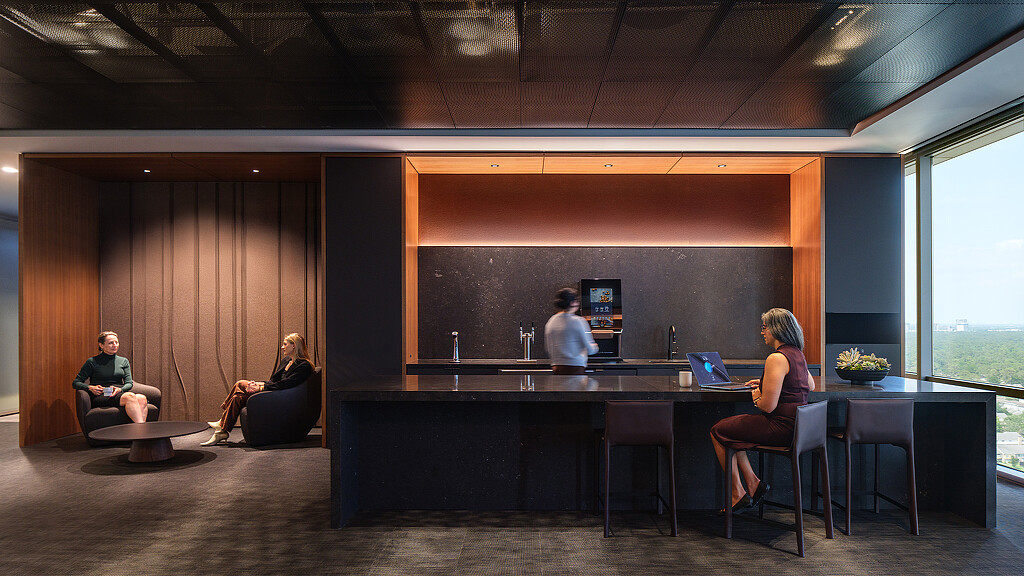 A group of people sitting at a table with laptops.