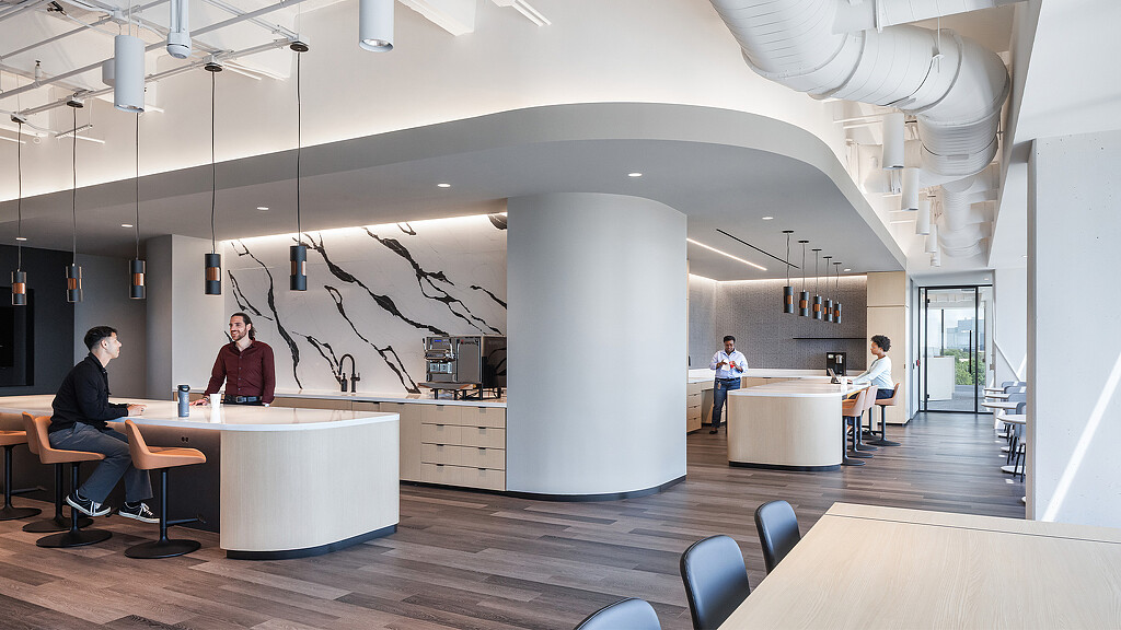 A group of people sitting at a table in a room with white walls.