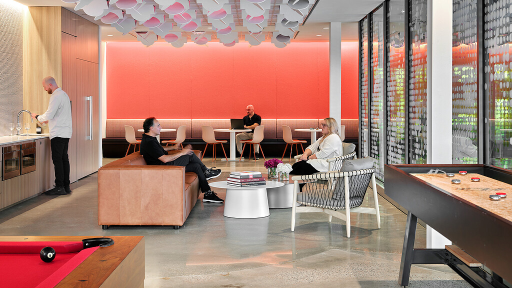 A group of people sitting in a room with a red wall.