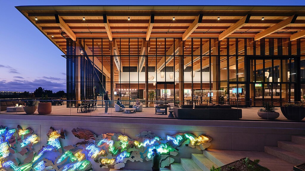 A building with a pool and a deck with lights.