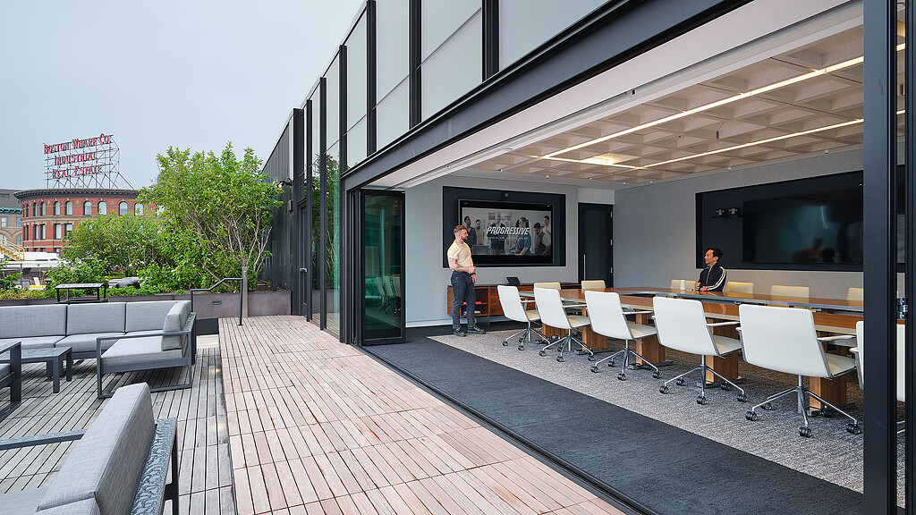 A building with a brick patio and tables and chairs.