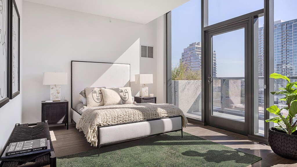 A bedroom with a large window.