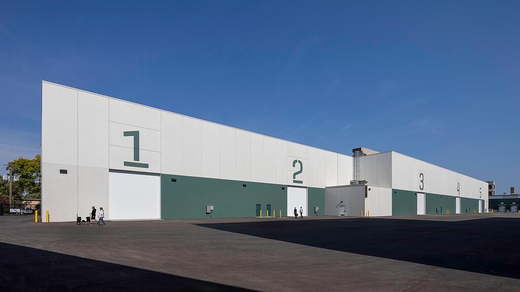 A large white building with people walking by it.