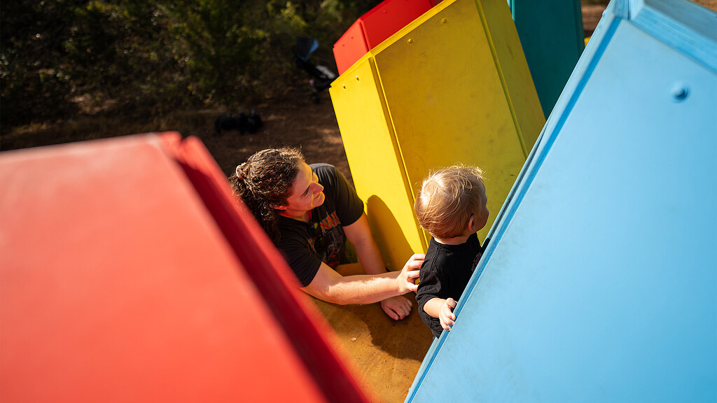 A couple of kids playing in a large water slide.