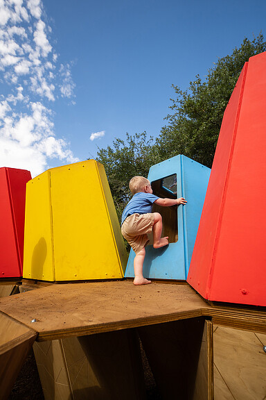 A baby playing in a play structure.