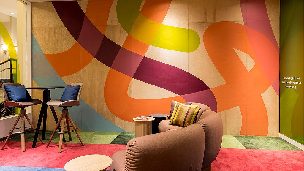 A room with chairs and a wall with a cartoon.