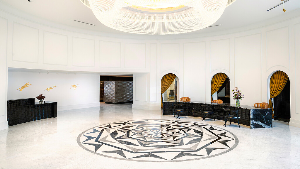 A large room with a large rug and chairs.