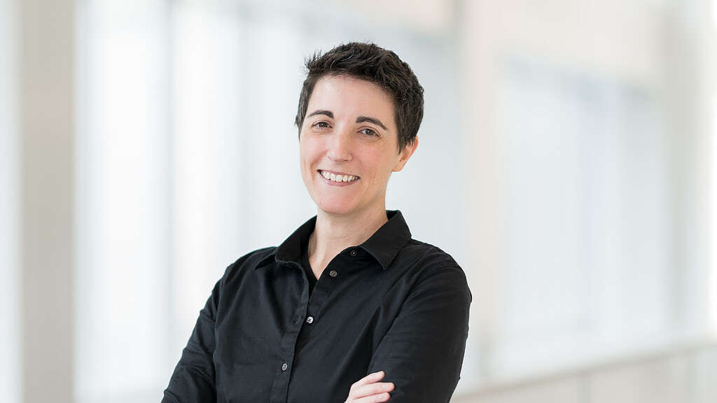 A man smiling with his arms crossed.