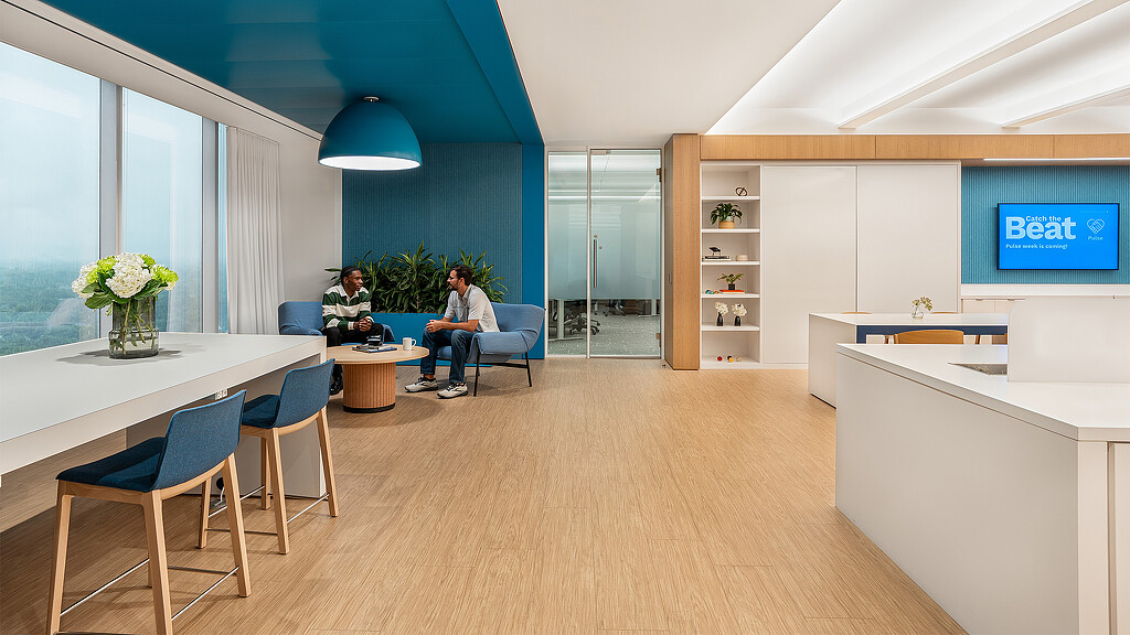A couple of people sitting at a table in a room with a large window.