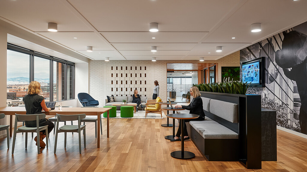 A group of people sitting in a room with a tv and a table.