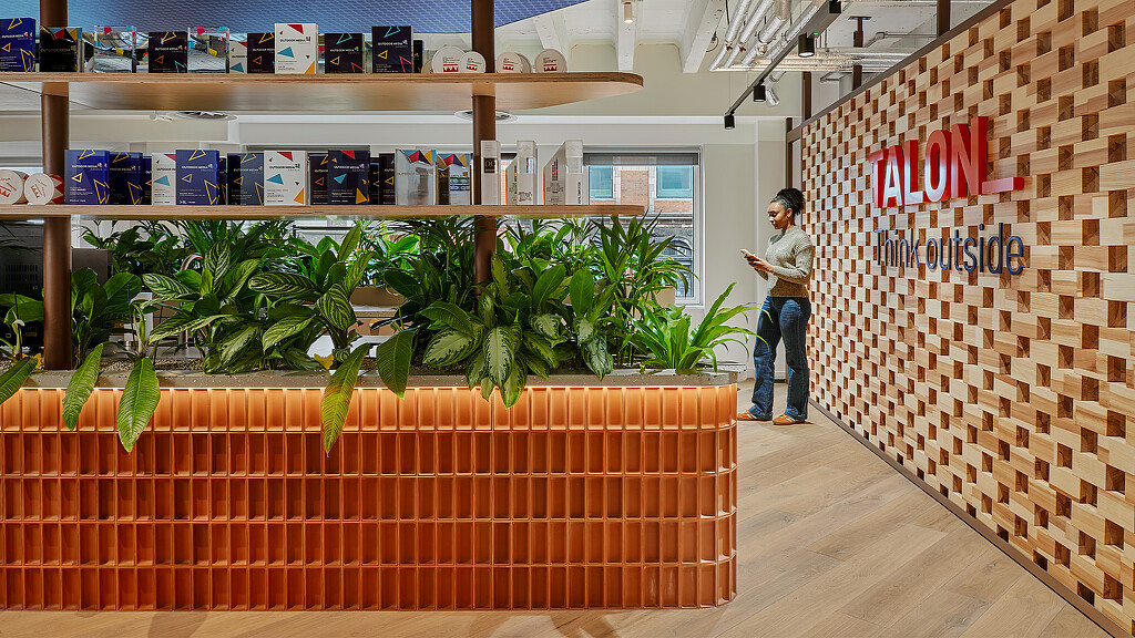 A person standing in a room with shelves and plants.