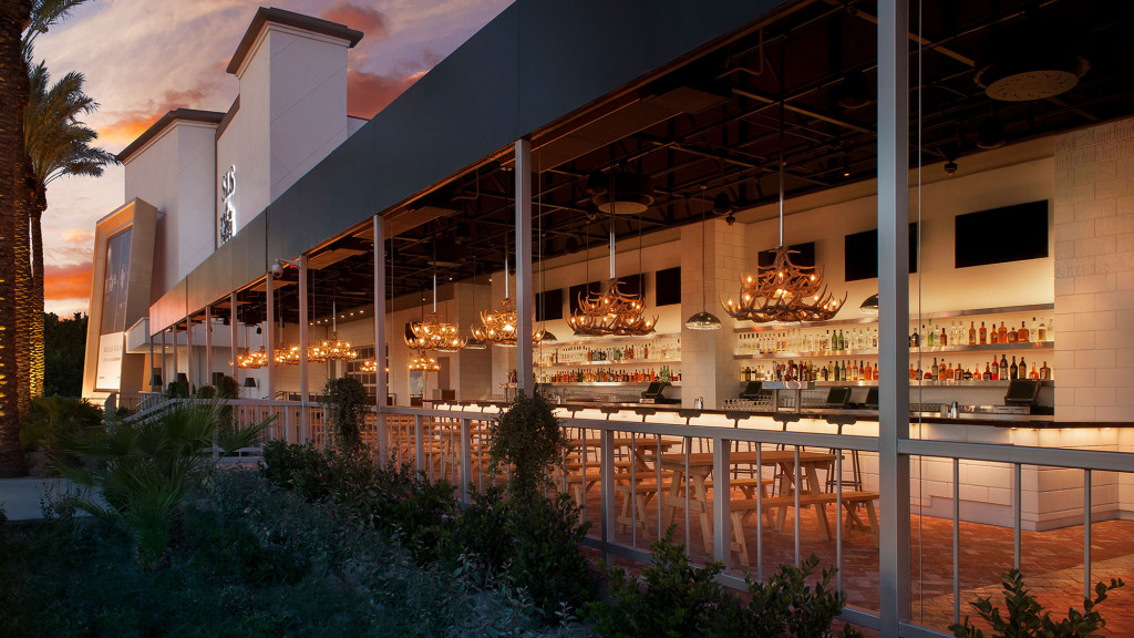 A house with a pool and a deck with a fire pit.