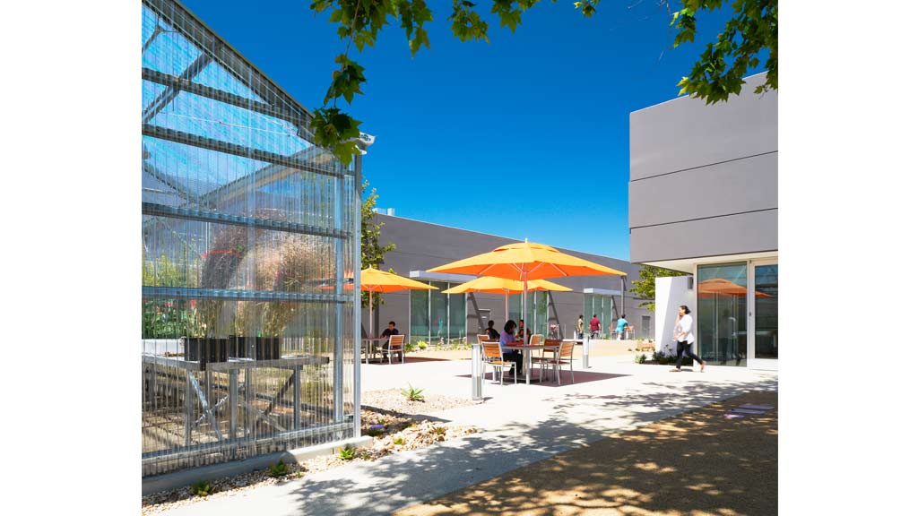 A group of people sit outside a building.