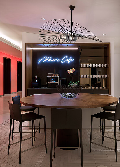 A table with chairs and a chandelier above it.