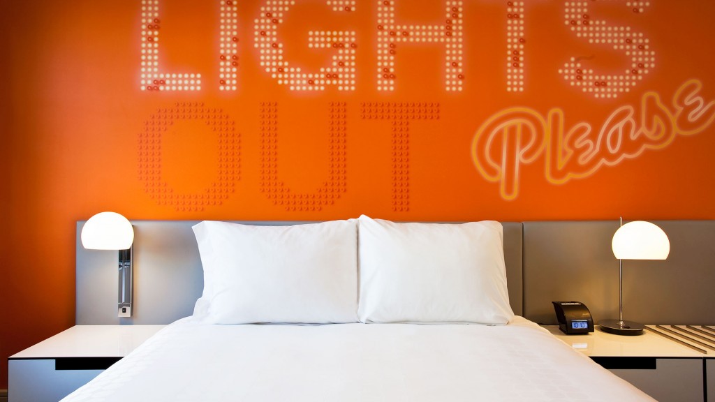 A bed with a white bed spread.