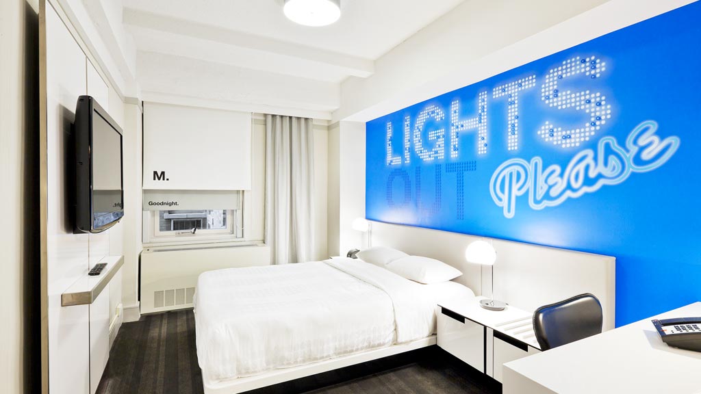 A bedroom with a large blue screen.