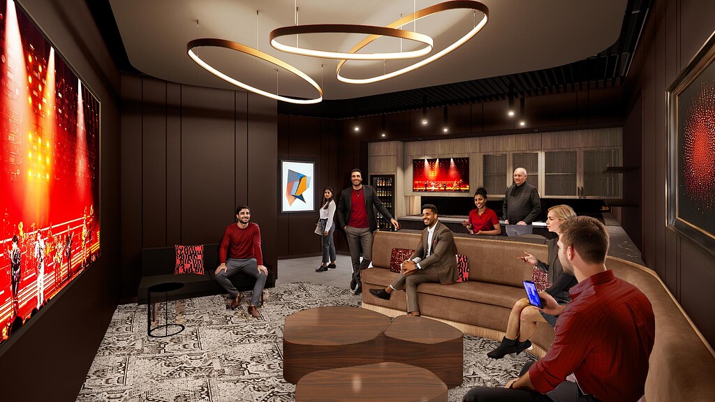 A group of people sitting in a room with a large screen.