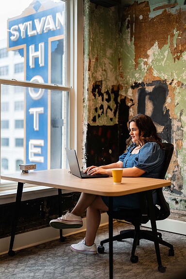 A person sitting at a table with a laptop.