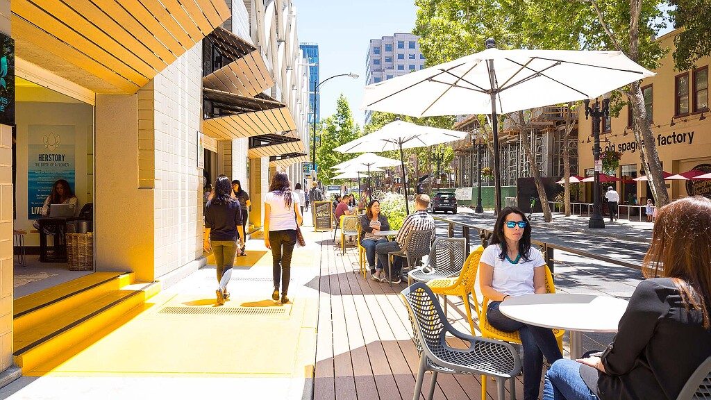 People sitting at tables outside.