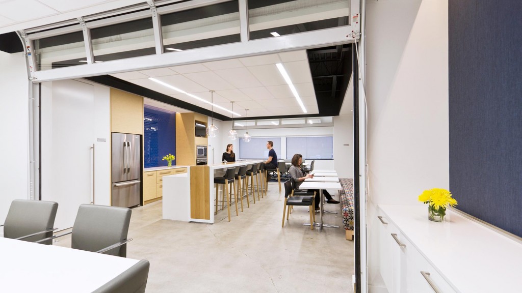 A group of people sitting at a table in a room with white walls.