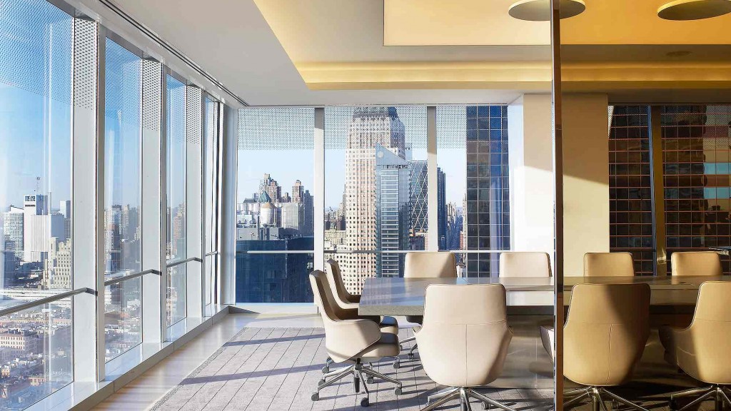 A room with a large window and a view of a city.