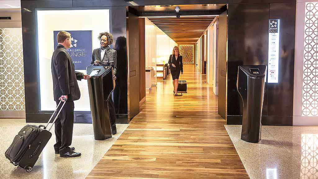 People with luggage in a hallway.