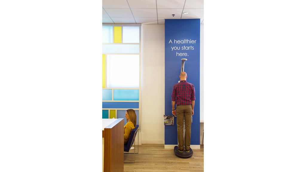 A man and a woman in a room with a blue sign.