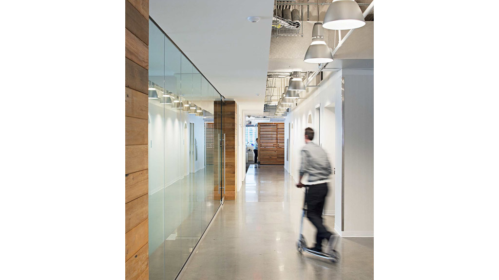 A man riding a skateboard down a hallway.