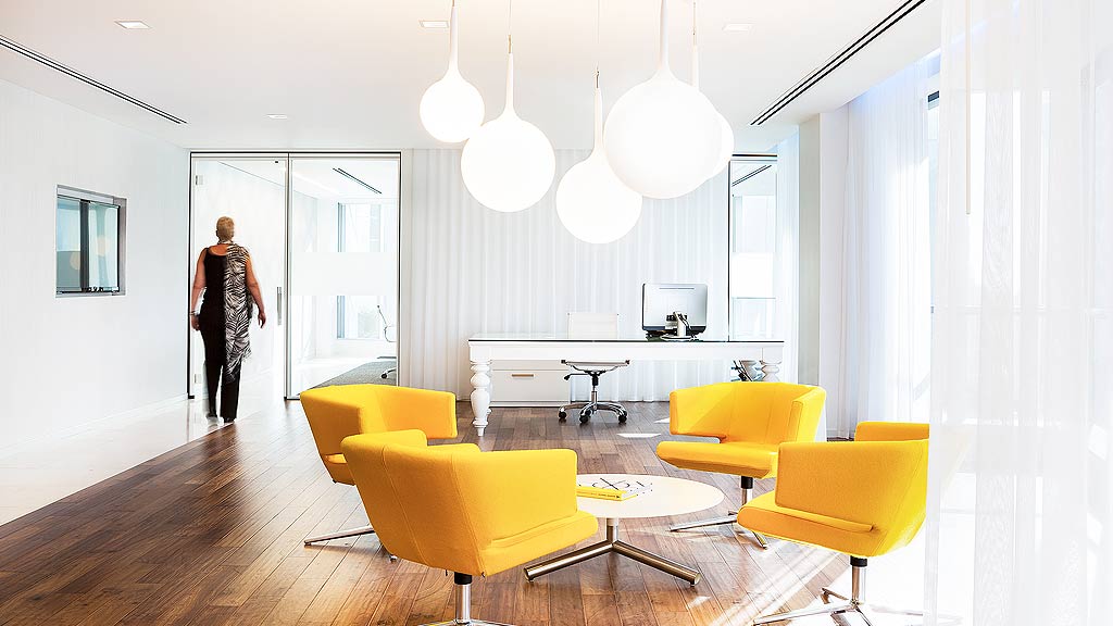 A room with a table chairs and a person in the background.