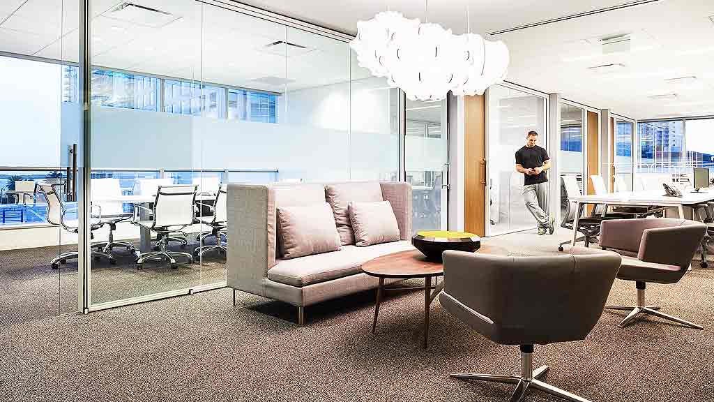 A room with a couch and chairs.