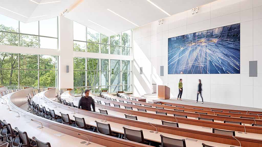 A room with a large table and chairs and a large painting on the wall.