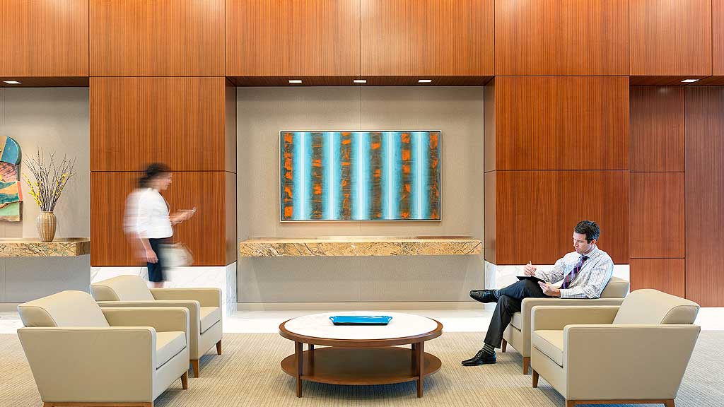 A man and a woman in a room with a large screen.