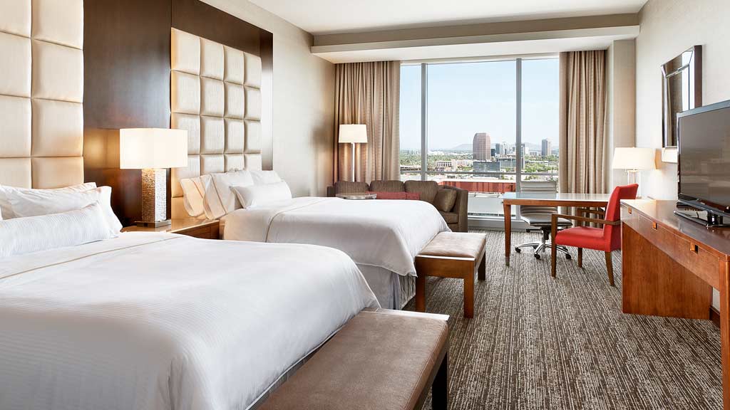 A hotel room with a large window.