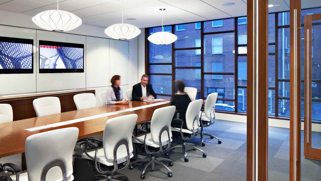 A group of people sitting at a table in a conference room.