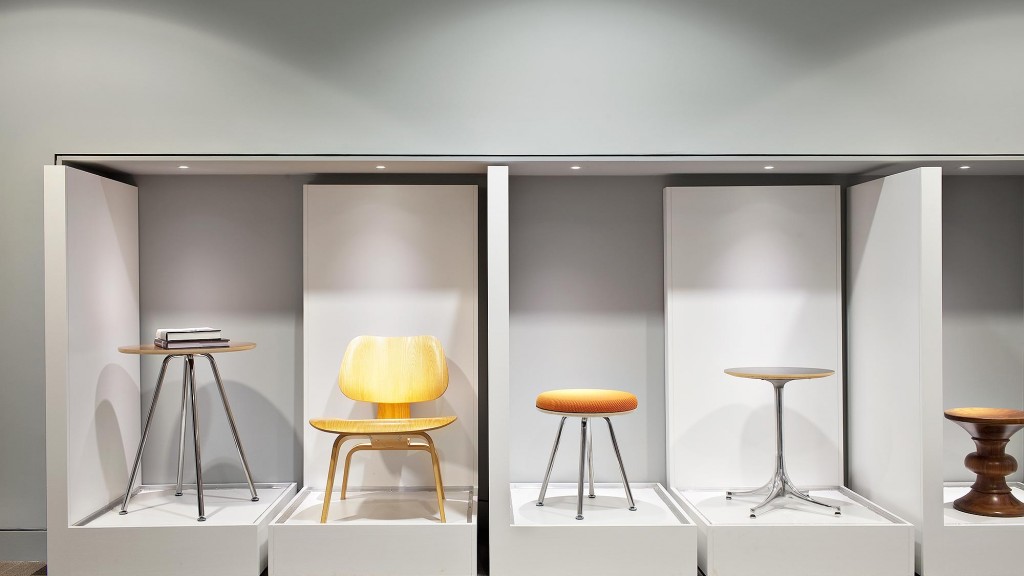 A white room with a white wall and a white table with stools.