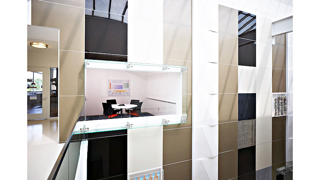 A room with a glass wall and a counter with a chair and a table.