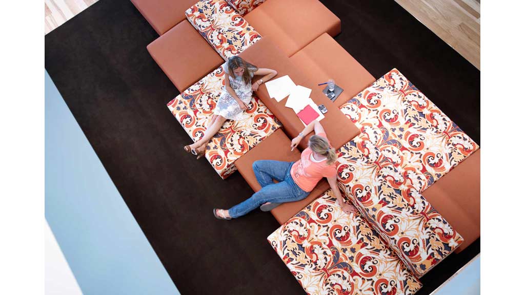 Two women lying on a rug.