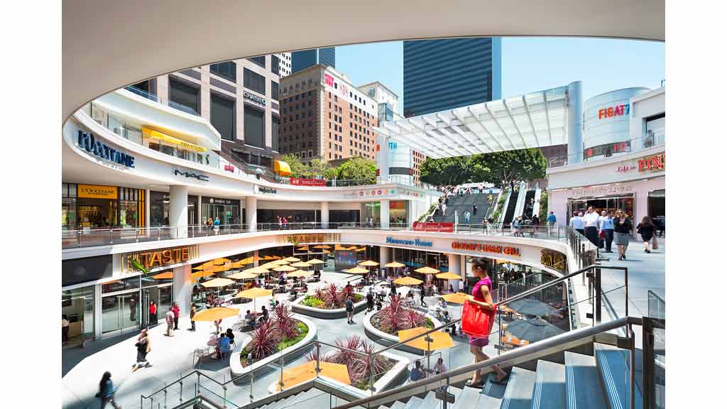 A large group of people walking around a shopping mall.