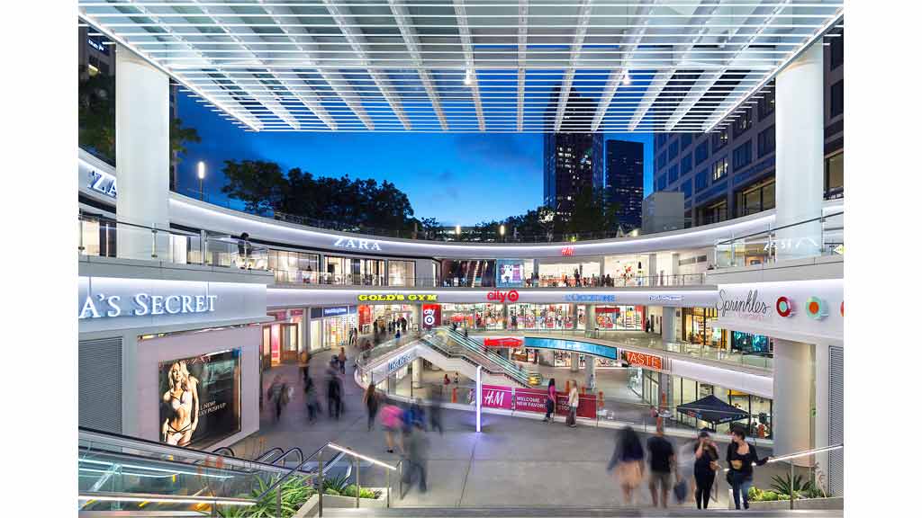 A group of people walking around a building.