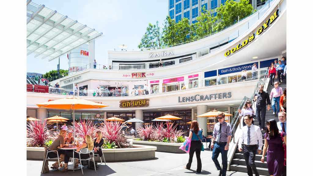 A group of people walking around a building.