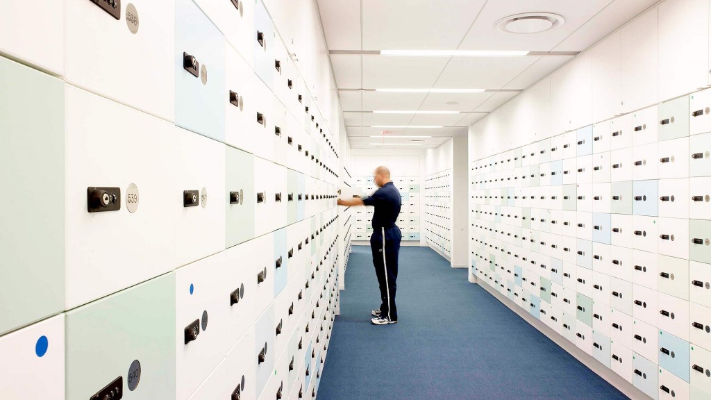 A person standing in a room full of white lockers.