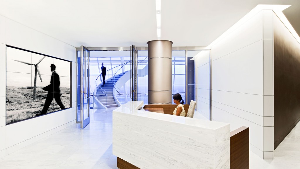 A person sitting at a desk in a room with a large window.