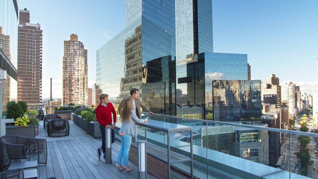 A man and woman walking on a bridge over a city.