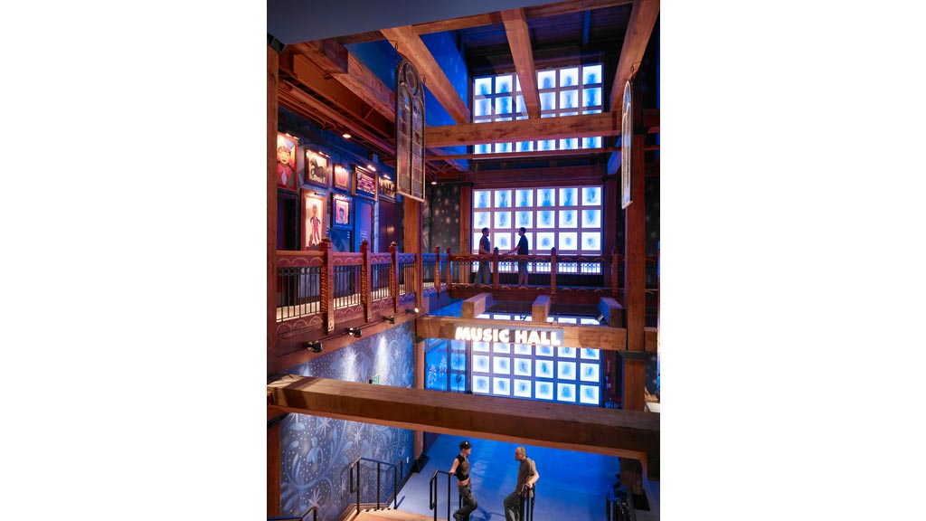 A group of people in a room with windows and a staircase.