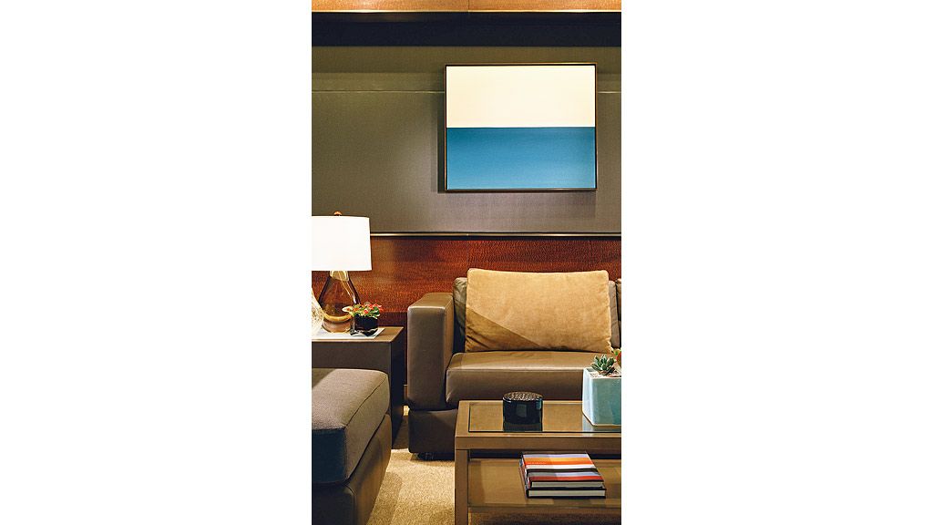 A room with a couch and a table with a lamp and a tv.