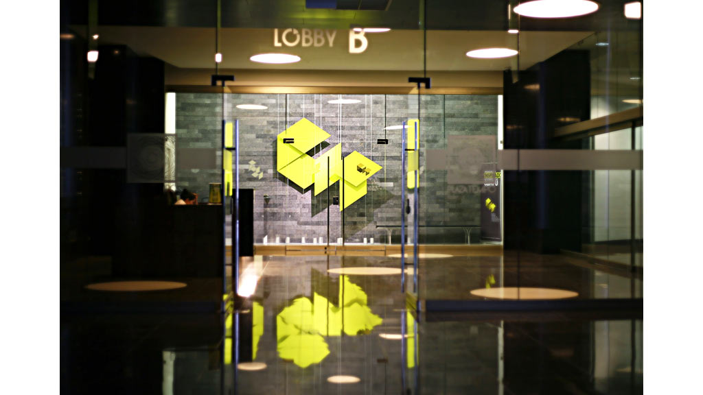 A glass walled building with a sign.