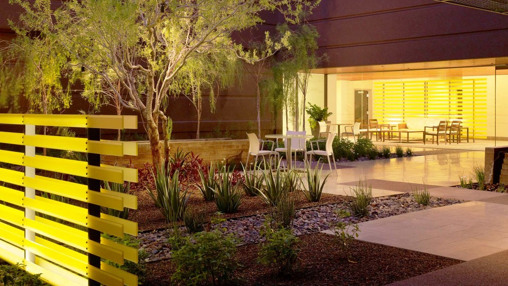 A patio with a table and chairs and a tree in the front.