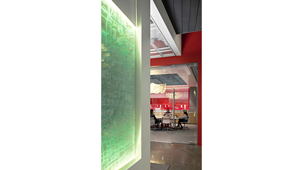 A group of people sitting at a table in a room with red walls.