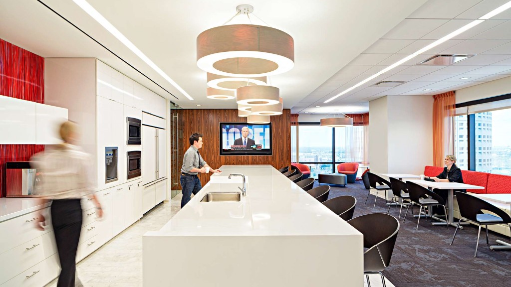 A couple of people in a room with tables and chairs.